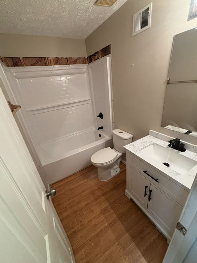 Finished bathroom with a new tub surround, toilet and vanity with black fixtures
